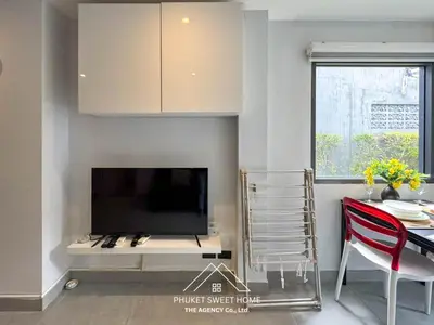 a living room with a flat screen tv and a dining table at Condo for rent chalong rawai 106 in Ban Klang