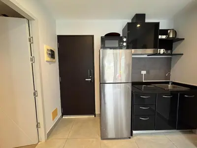 a kitchen with a stainless steel refrigerator and black cabinets at Condo for rent chalong rawai 106 in Ban Klang