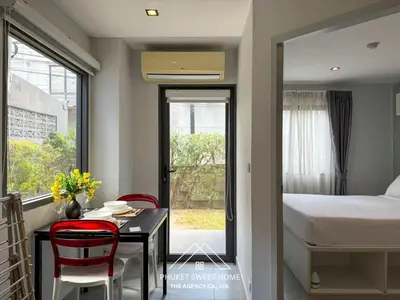 a bedroom with a bed and a table and chairs at Condo for rent chalong rawai 106 in Ban Klang