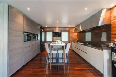 a kitchen with a table and chairs in it at 35 - Vast Beach Front Villa in Kamala Beach