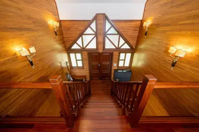 a staircase in a house with wooden walls and wood floors at 35 - Vast Beach Front Villa in Kamala Beach