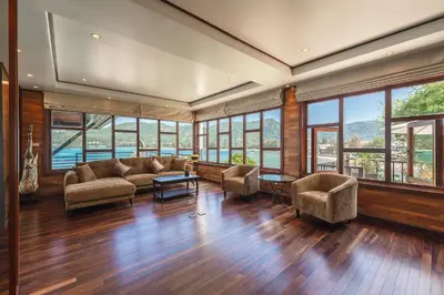 a living room with a couch and chairs and windows at 35 - Vast Beach Front Villa in Kamala Beach