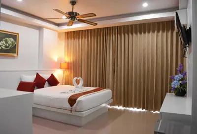 a bedroom with a bed and a large window at Angelina Guesthouse in Patong Beach
