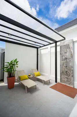 a patio with two chairs and a large window at Villa Asteria Krabi - Luxury 3 Bedroom Pool Retreat in Ao Nang in Ban Khlong Haeng