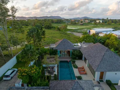 an aerial view of a house with a swimming pool at BangTao Luxury 5 Bedroom 1200sqm Modern Bali Style Holiday Villa Quiet and Private Large Private Pool Large Garden in Bang Tao Beach