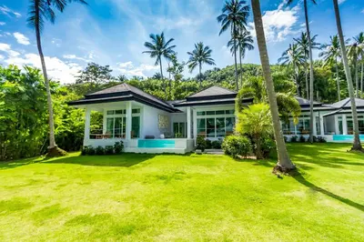 a house with palm trees in front of it at Baan Klong III in Ko Yao Noi