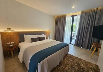 a bedroom with a large bed and a large window at La La Lay Beach House in Klong Muang Beach