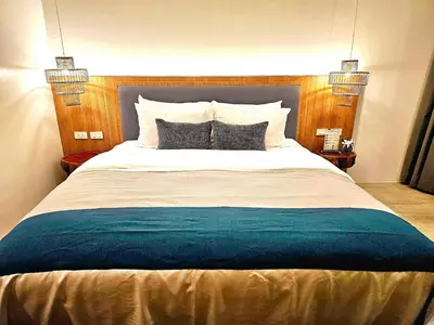 a bedroom with a large bed with two pillows at La La Lay Beach House in Klong Muang Beach