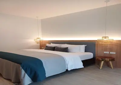 a bedroom with a large white bed with two lights at La La Lay Beach House in Klong Muang Beach