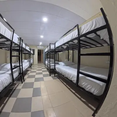 a room with four bunk beds on a checkered floor at Vista Inn Patong in Patong Beach