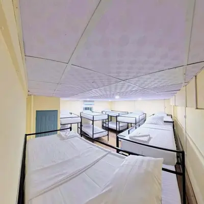 a room with several beds and tables in it at Vista Inn Patong in Patong Beach