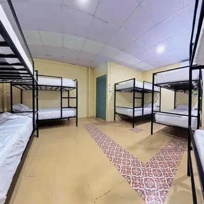 a room with three bunk beds and a rug at Vista Inn Patong in Patong Beach