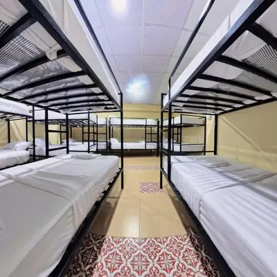 a room with three bunk beds and a rug at Vista Inn Patong in Patong Beach