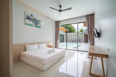 a bedroom with a bed and a sliding glass door at Elm pool villa Phuket in Kata Beach