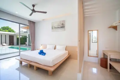 a bedroom with a bed and a swimming pool at Elm pool villa Phuket in Kata Beach