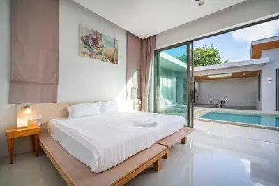 a bedroom with a bed and a swimming pool at Elm pool villa Phuket in Kata Beach