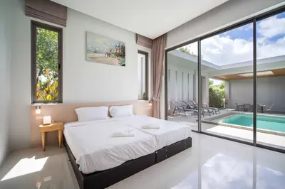 a bedroom with a large bed and a swimming pool at Elm pool villa Phuket in Kata Beach