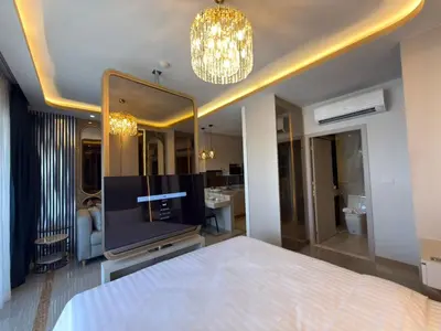 a bedroom with a television and a large mirror at Новая студия Bellevue Bangtao in Laguna Phuket