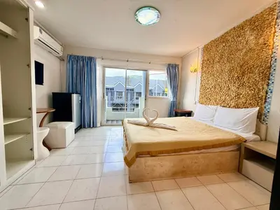 a hotel room with a bed and a large window at Om Sab House Patong in Patong Beach