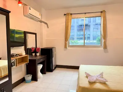 a hotel room with a bed and a window at Om Sab House Patong in Patong Beach