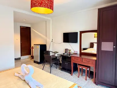 a hotel room with a bed and a desk and a mirror at Om Sab House Patong in Patong Beach