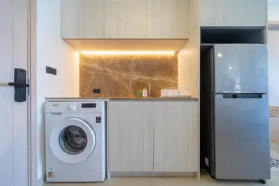 a kitchen with a washing machine and a refrigerator at Ozone Condominium BangTao Laguna Area in Phuket