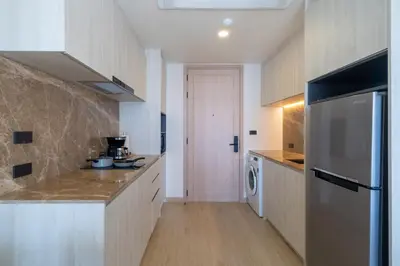 a kitchen with a refrigerator and a washer and dryer at Ozone Condominium BangTao Laguna Area in Phuket