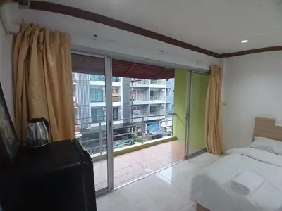 a bedroom with a bed and a large window at Didim Guest House Patong in Patong Beach
