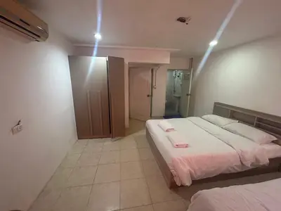 a bedroom with two beds in a room with lights at Didim Guest House Patong in Patong Beach