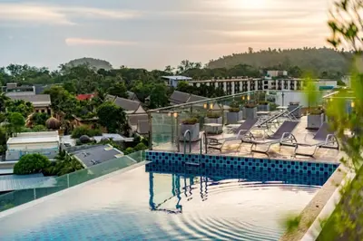 a swimming pool with chairs on top of a building at 1 BR Suite 8-198 at Ozone Condo near Kata beach and surf in Kata Beach