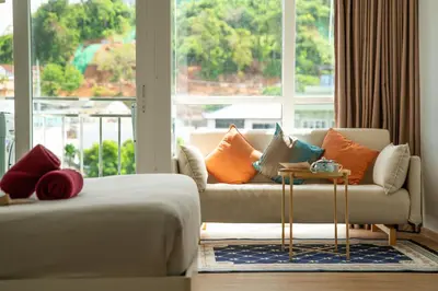 a living room with a couch and a large window at 1 BR Suite 8-198 at Ozone Condo near Kata beach and surf in Kata Beach
