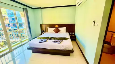a bedroom with a bed and a large window at Hotel Hollywood Inn Love Patong in Patong Beach