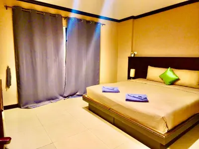 a bedroom with a bed with two towels on it at Hotel Hollywood Inn Love Patong in Patong Beach