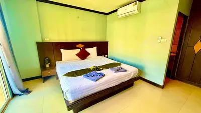 a bedroom with a bed with two towels on it at Hotel Hollywood Inn Love Patong in Patong Beach