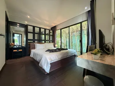 a bedroom with a bed and a large window at 2 Bedroom Pool Villa Chalong in Chalong