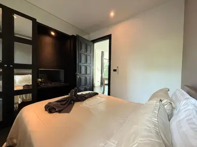 a bedroom with a bed with a robe on it at 2 Bedroom Pool Villa Chalong in Chalong