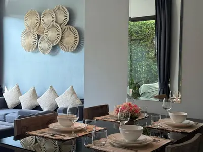a dining room with tables and a blue couch at 2 Bedroom Pool Villa Chalong in Chalong