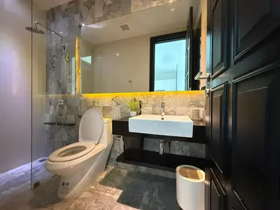 a bathroom with a toilet and a sink and a mirror at 2 Bedroom Pool Villa Chalong in Chalong