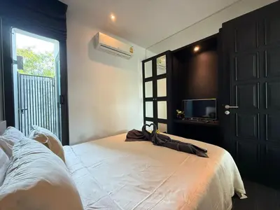 a bedroom with a white bed and a television at 2 Bedroom Pool Villa Chalong in Chalong