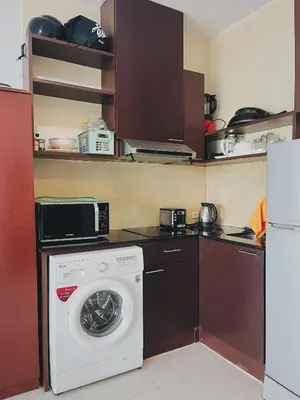 a kitchen with a washing machine and a microwave at CHIC Beautiful apartment by the seaside, terrace, pool, free gym in Karon Beach