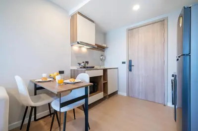 a kitchen and dining room with a table and chairs at Cosy 1 bedroom apt at Space Cherngtalay - 402 in Bang Tao Beach