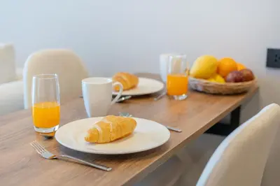 a table with two plates of food and orange juice at Cosy 1 bedroom apt at Space Cherngtalay - 402 in Bang Tao Beach