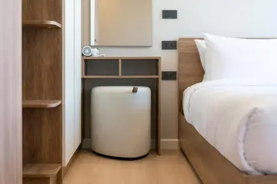 a bedroom with a bed and a small table next to a radiator at Cosy 1 bedroom apt at Space Cherngtalay - 402 in Bang Tao Beach