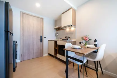 a kitchen and dining room with a table and chairs at Brand new 1 BR apt 403 at Space Condo near Boat Avenue in Bang Tao Beach