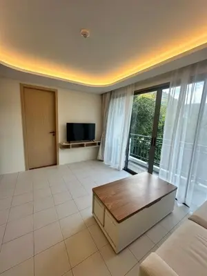 a living room with a couch and a tv at FantaSea Kamala By Ere in Kamala Beach