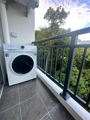 a washing machine sitting on the balcony of a house at FantaSea Kamala By Ere in Kamala Beach