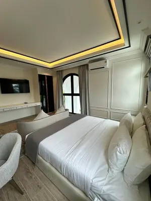 a bedroom with a large white bed and a couch at Fifth Element Pool Villa By Ere in Laguna Phuket