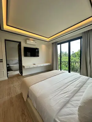 a bedroom with a large bed and a large window at Fifth Element Pool Villa By Ere in Laguna Phuket