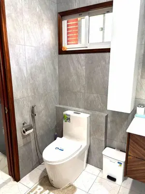 a bathroom with a white toilet and a window at Relife apartments Большая квартира с панорамным видом на горы на Най Харне in Phuket Town
