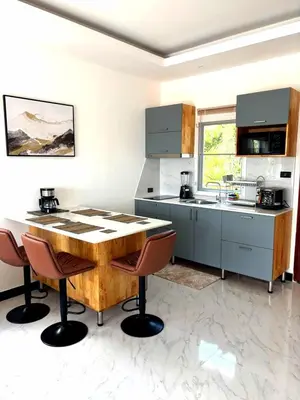 a kitchen with a wooden table and chairs at Relife apartments Большая квартира с панорамным видом на горы на Най Харне in Phuket Town